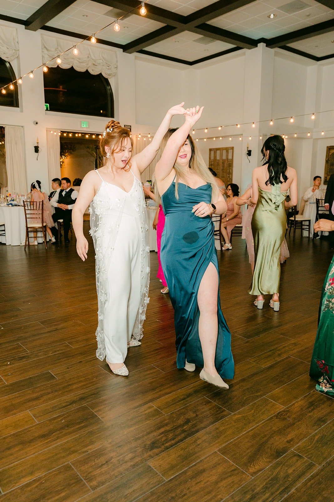 Joanna dancing with her bridesmaids on the wood floor