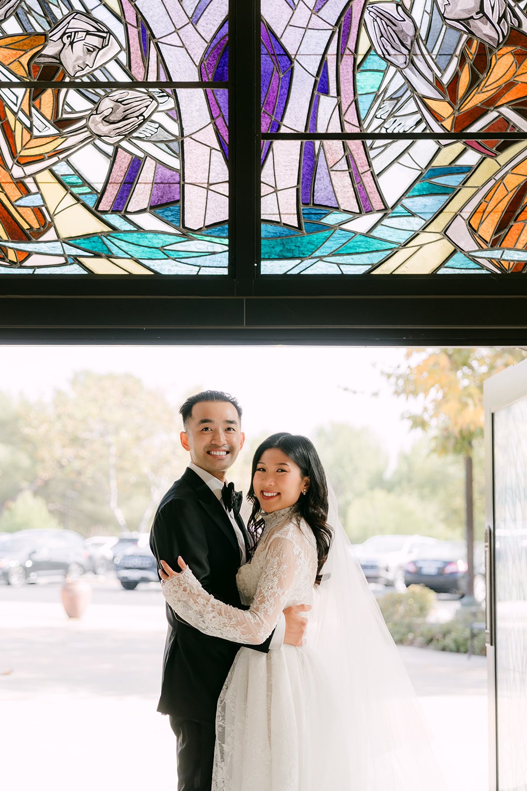 Kim and Vincent beneath a stained glass window