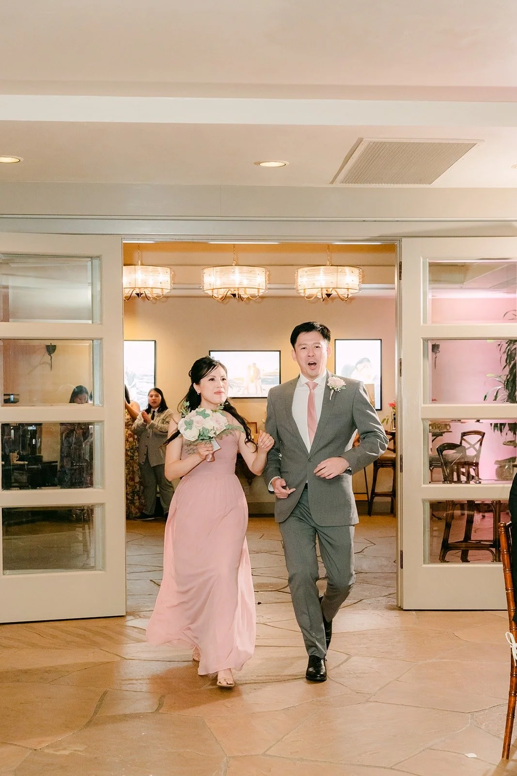 A bridesmaid and groomsman walking into the reception