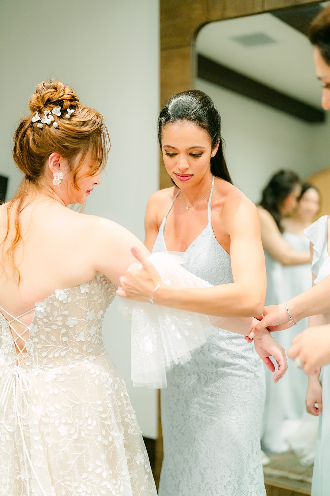 Bridesmaids helping Joanna into her gown