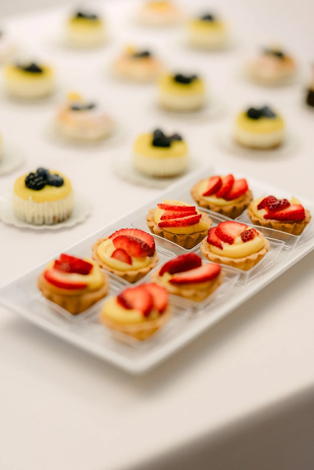 Mini fruit tarts on the dessert table, photographed by One and Only Production.
