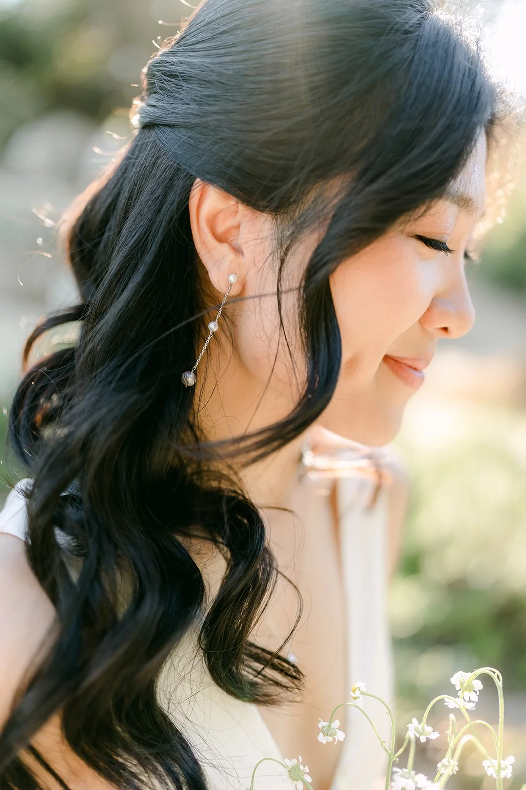 Profile of Kim with her hair swept to one side in soft afternoon light.