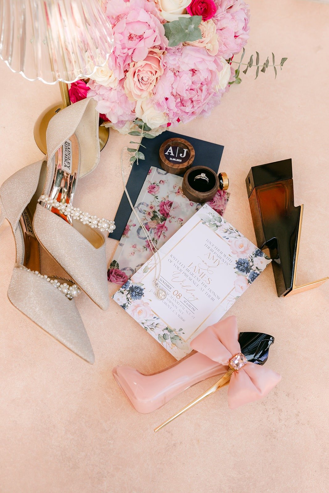 Amy and James's invitation, perfume and heels styled with pink roses