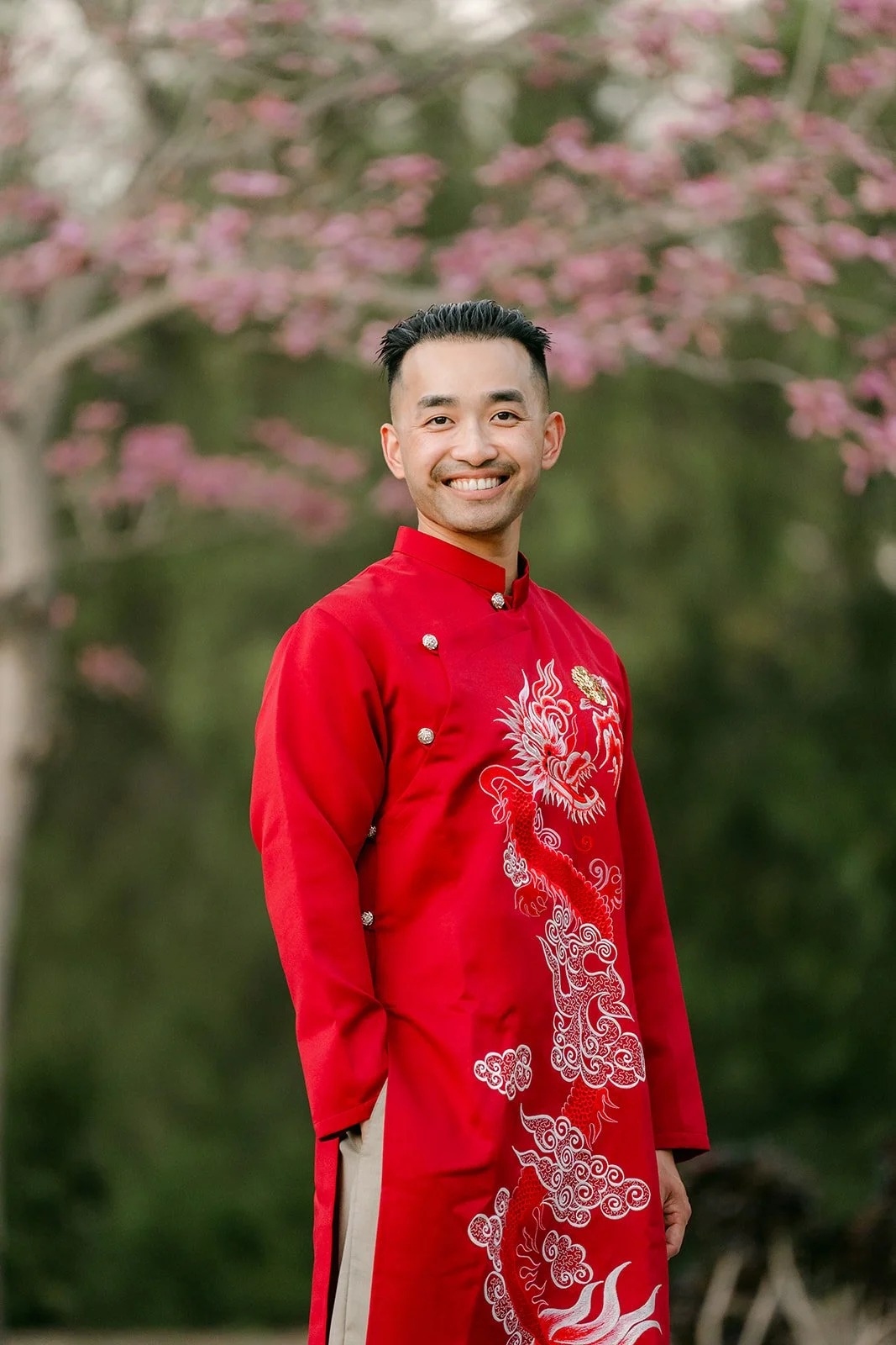 Vincent smiling in his embroidered red ao dai.