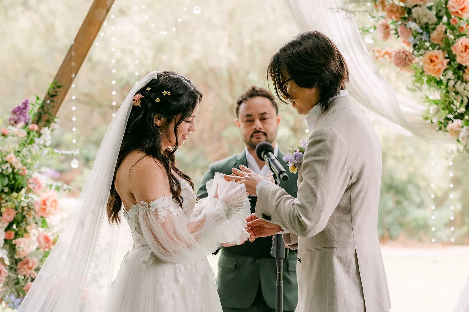 Kat and Mike holding hands under the floral arch