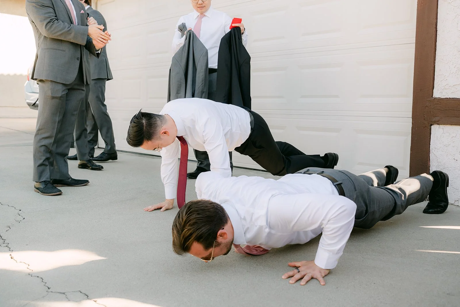 The groomsmen doing push ups in a row.
