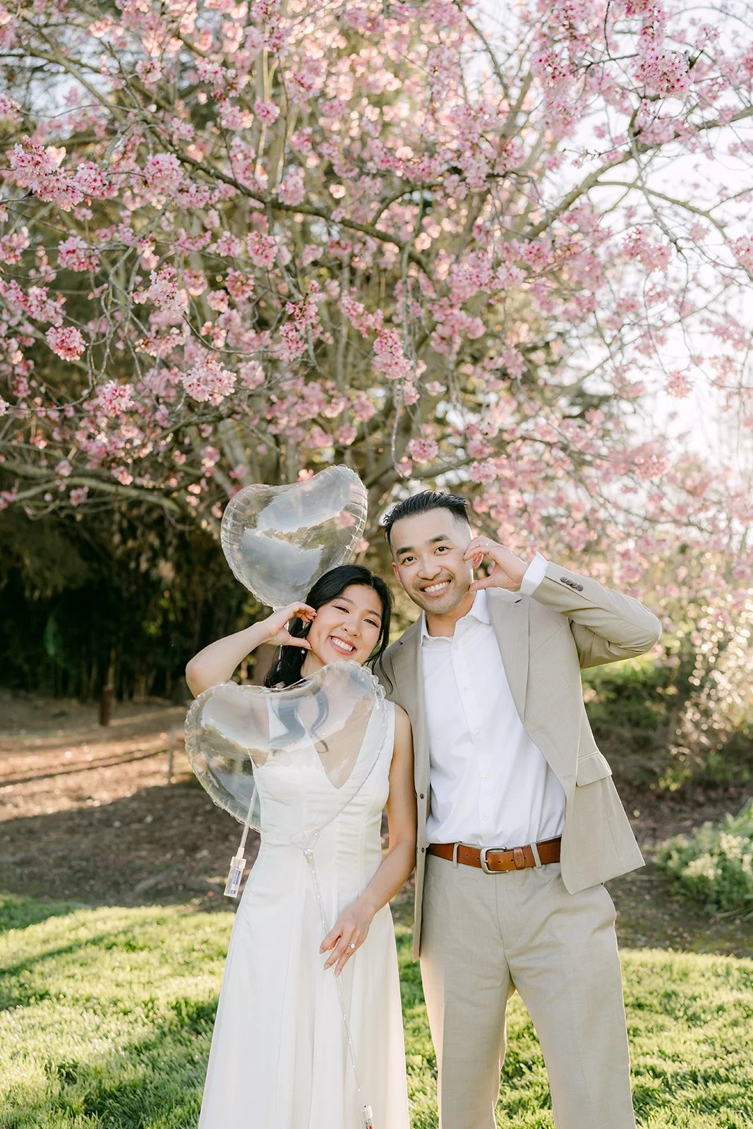 Kim and Vincent laughing together beneath the blossoming trees.
