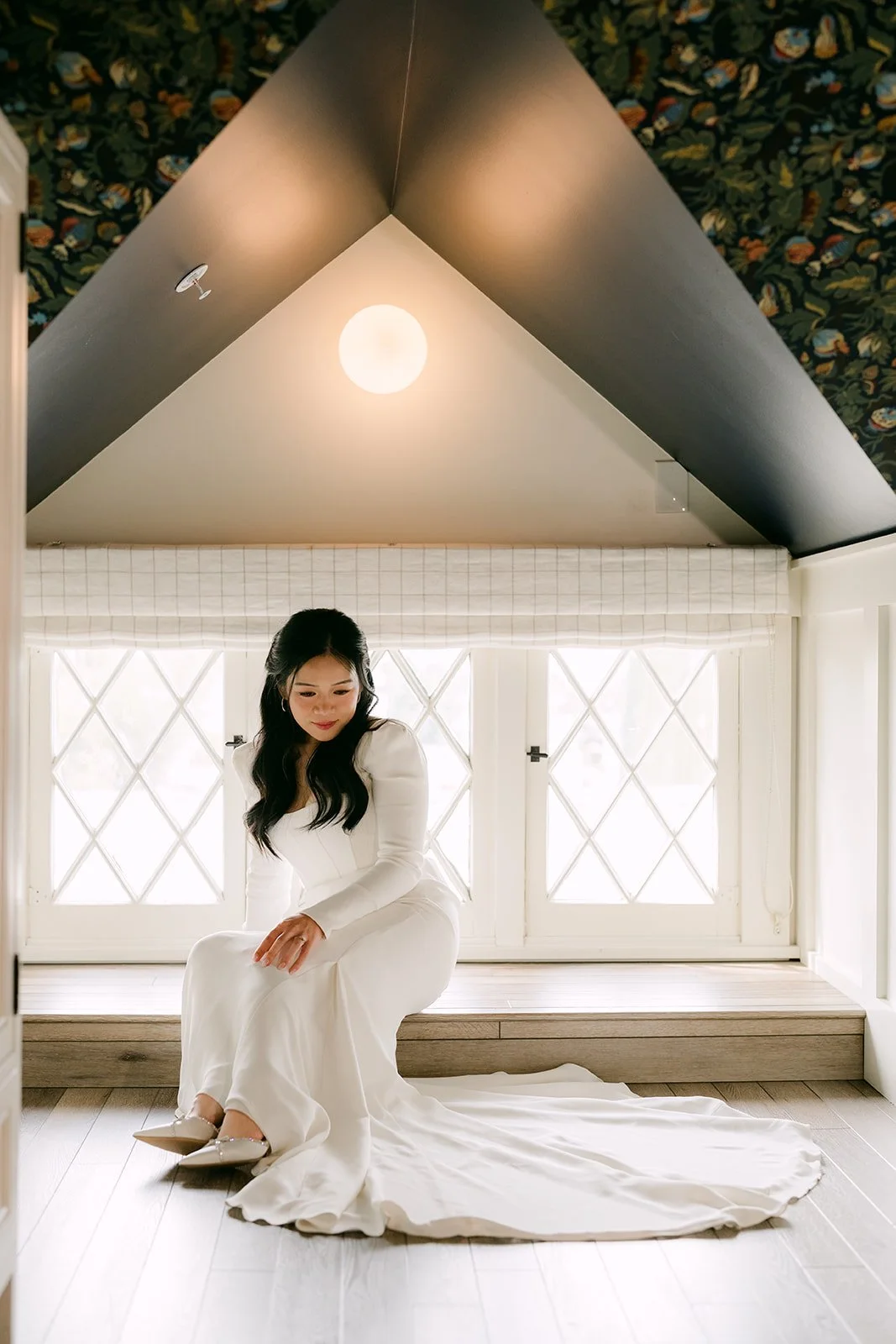 Denise seated in the attic window nook with her train spread across the floor.
