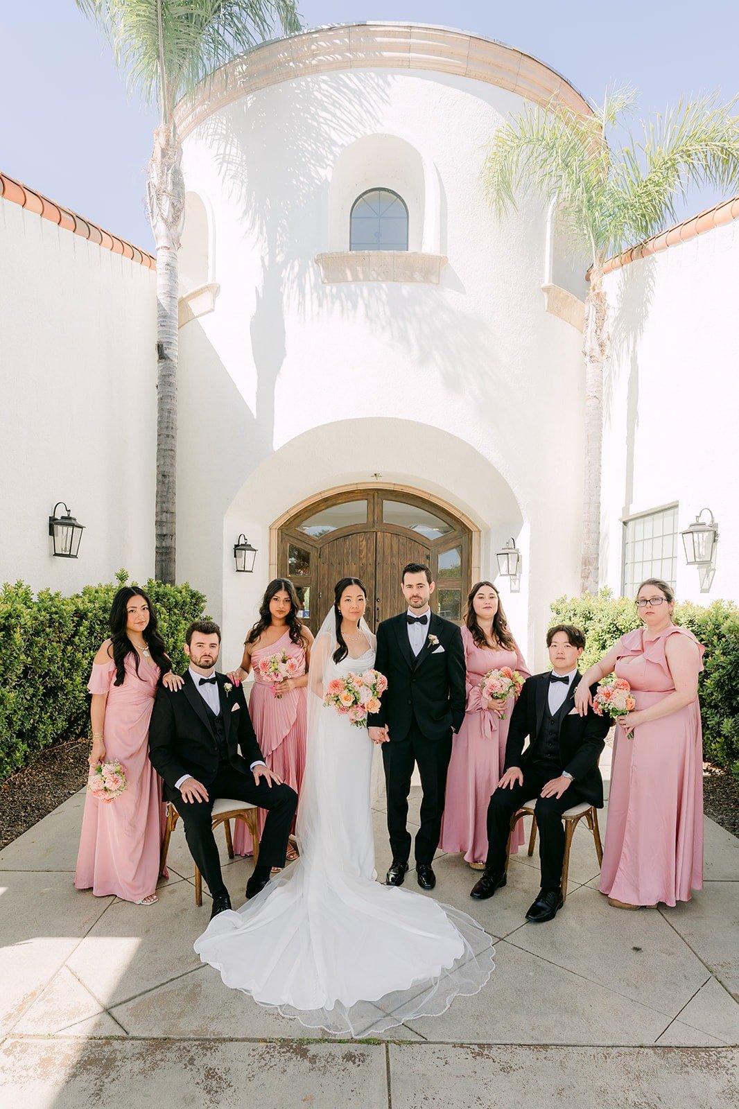 The wedding party gathered under the white arched entry tower at Sterling Hills