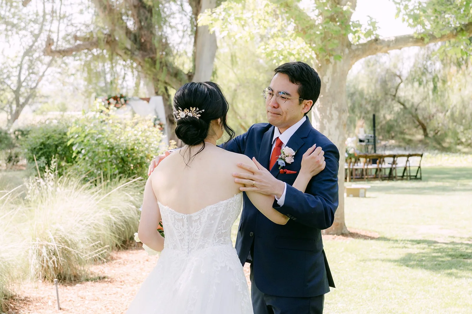 Bride touching the groom's face as he smiles after the first look