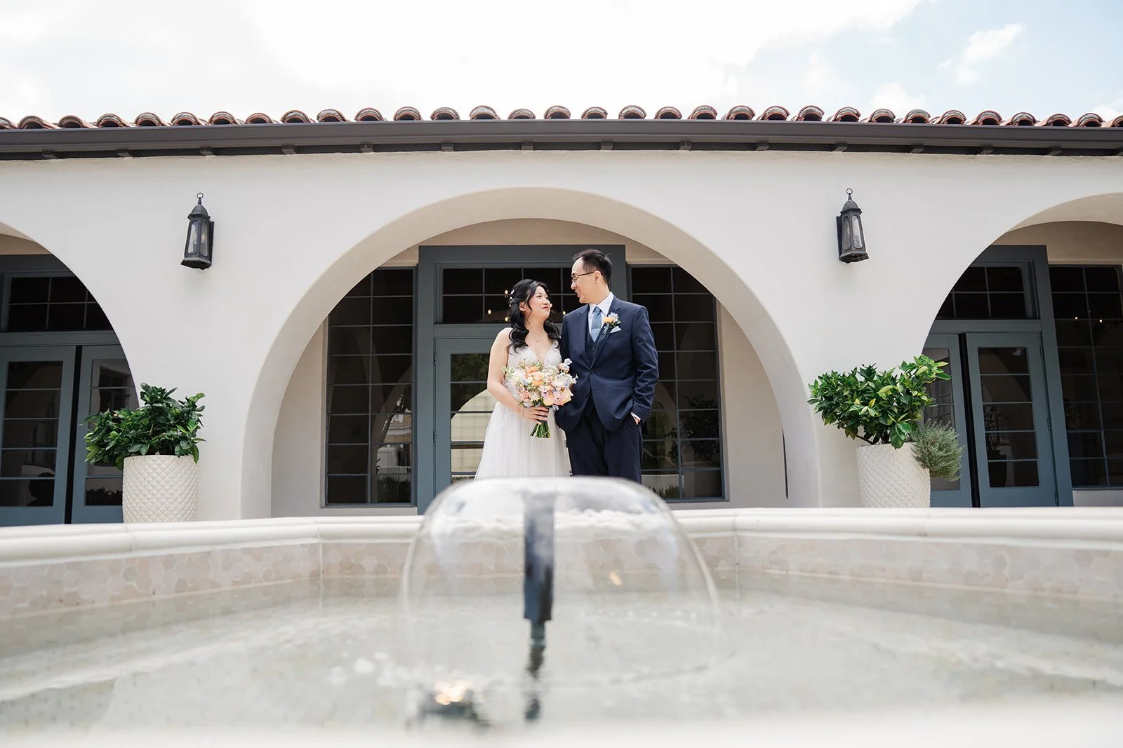 Constance and Lawrence standing behind the courtyard fountain at Grand Gimeno