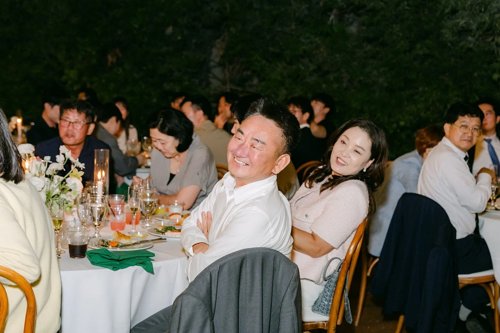 Guests laughing at their table during the toasts, photographed by One and Only Production