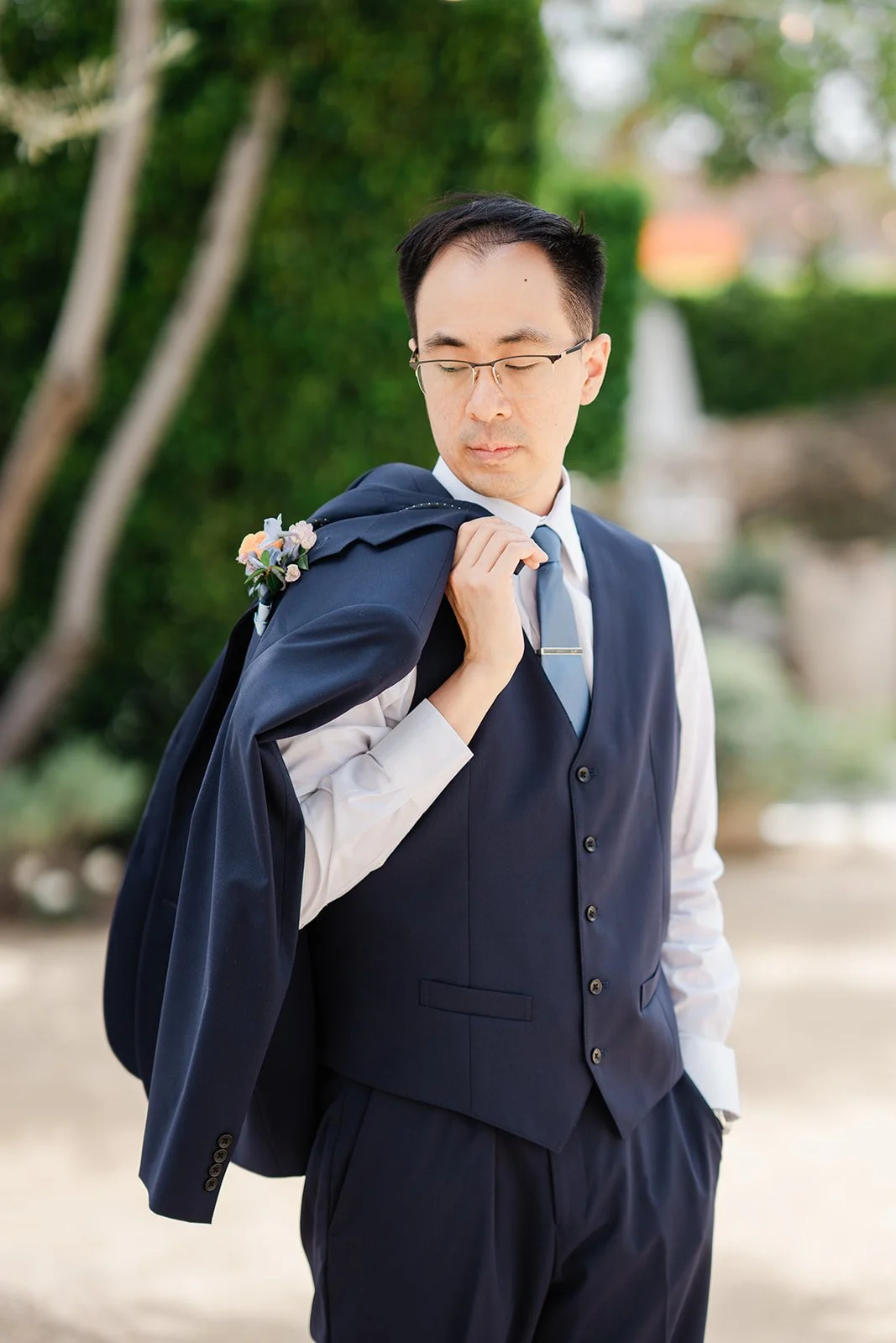Lawrence with his jacket over his shoulder in the garden
