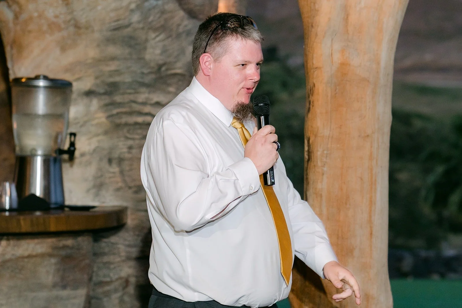 A groomsman with a gold tie giving his speech