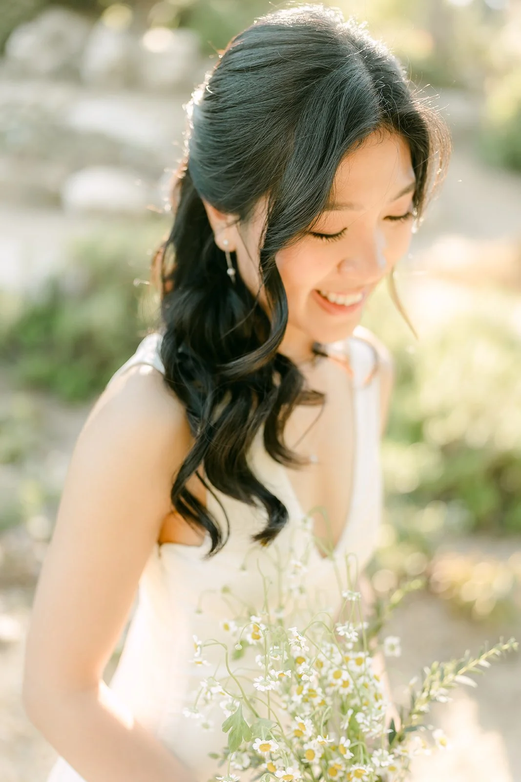 Kim looking down with her long dark curls over one shoulder.