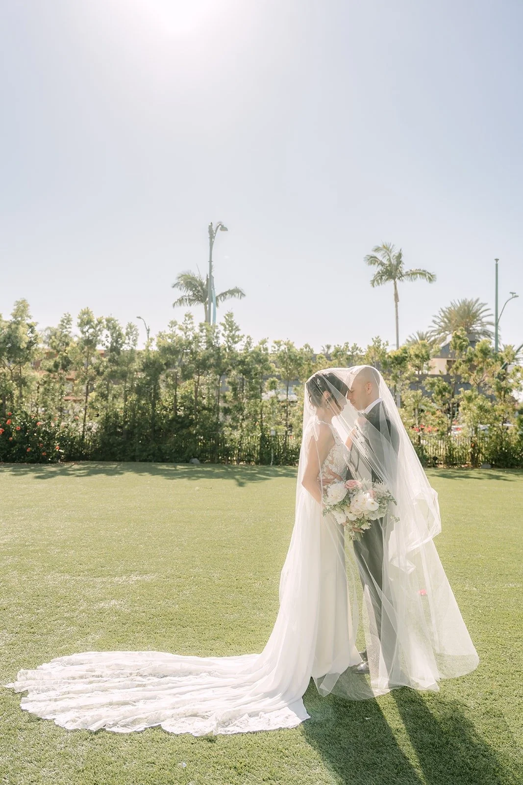 Francesca and Daniel embrace on the lawn as her train spreads around them