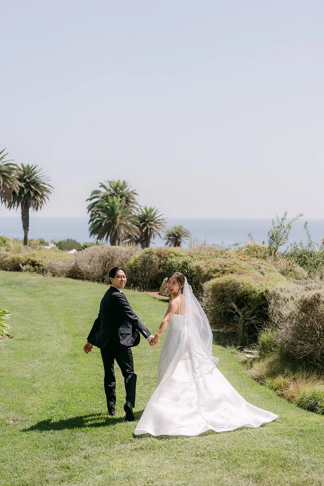 Walking hand in hand across the lawn at golden hour