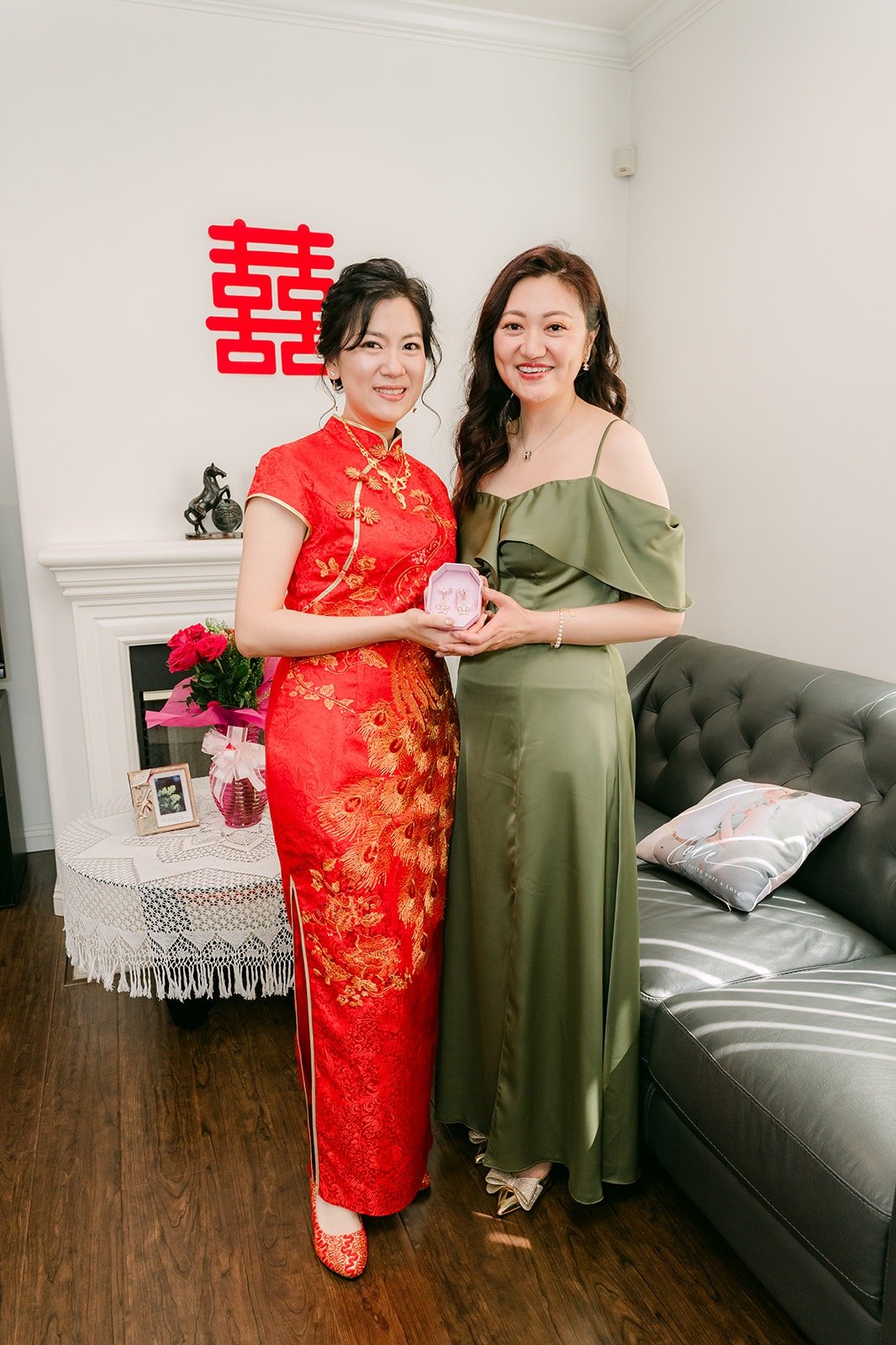 Eunice and a bridesmaid in olive green smile together after the gift exchange, photographed by One and Only Production