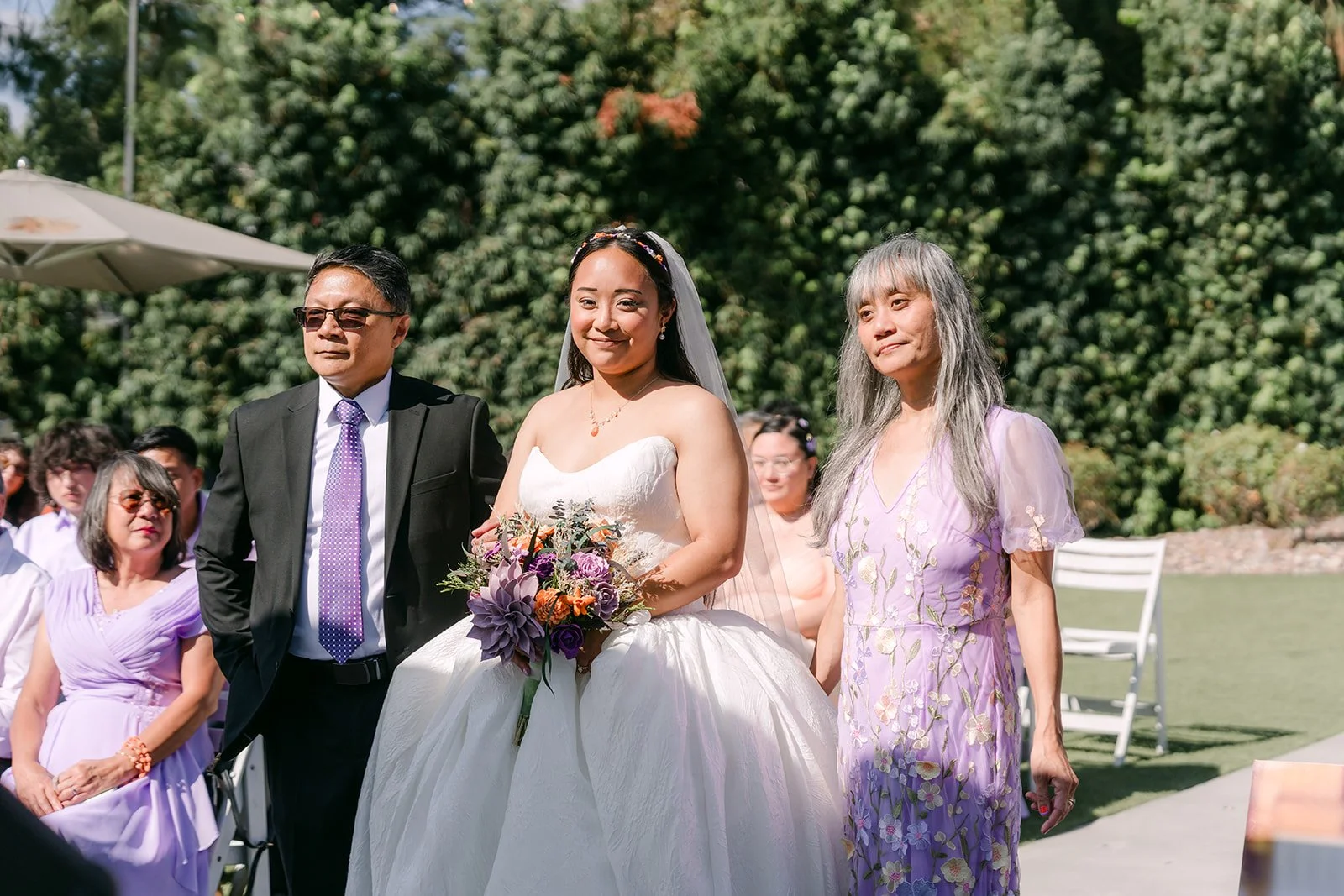 Angela and her parents walking down the aisle