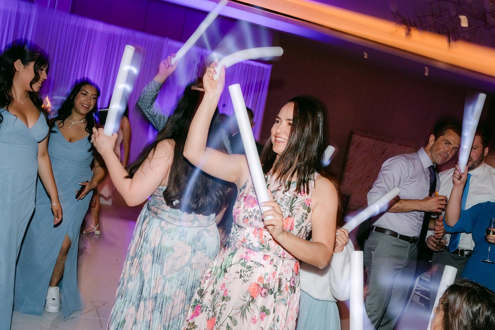 Bridesmaids dance with light sticks in the Carousel Ballroom