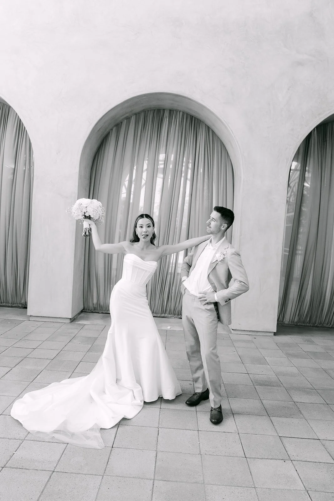 Black and white photo of the couple cheering after the ceremony