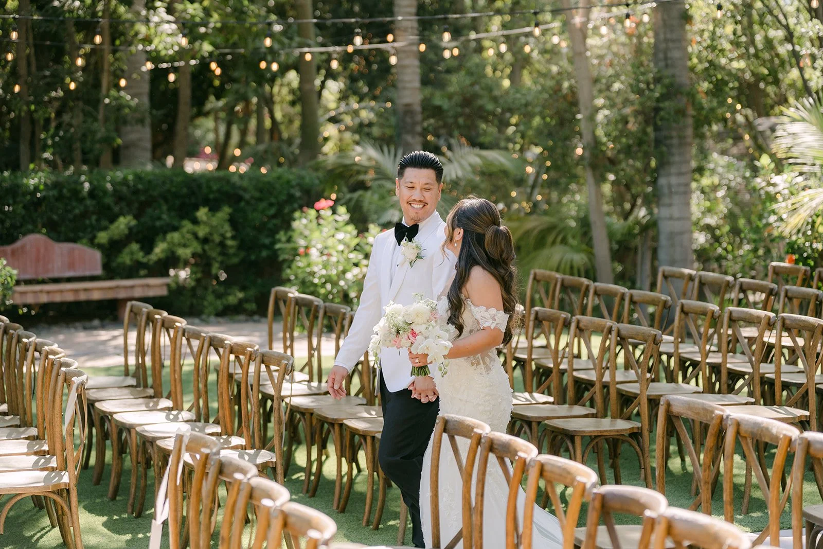 Caryl and Nicole smiling at each other between rows of ceremony chairs.