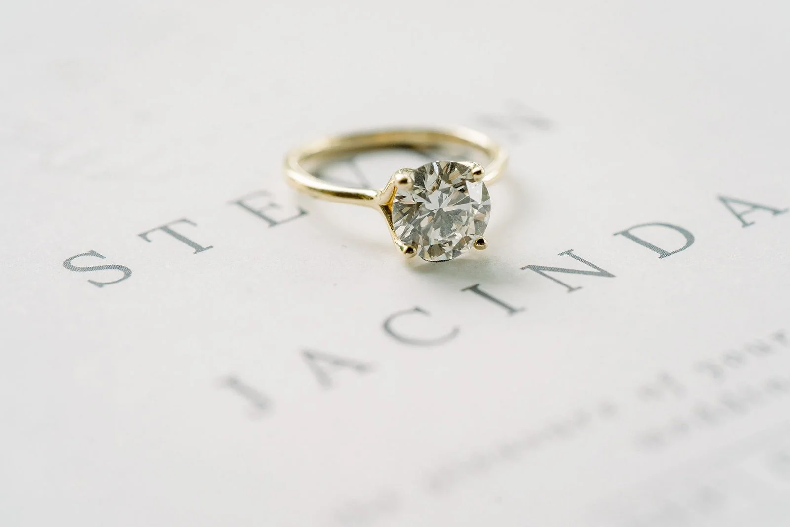 Jacinda's engagement ring resting on the wedding invitation