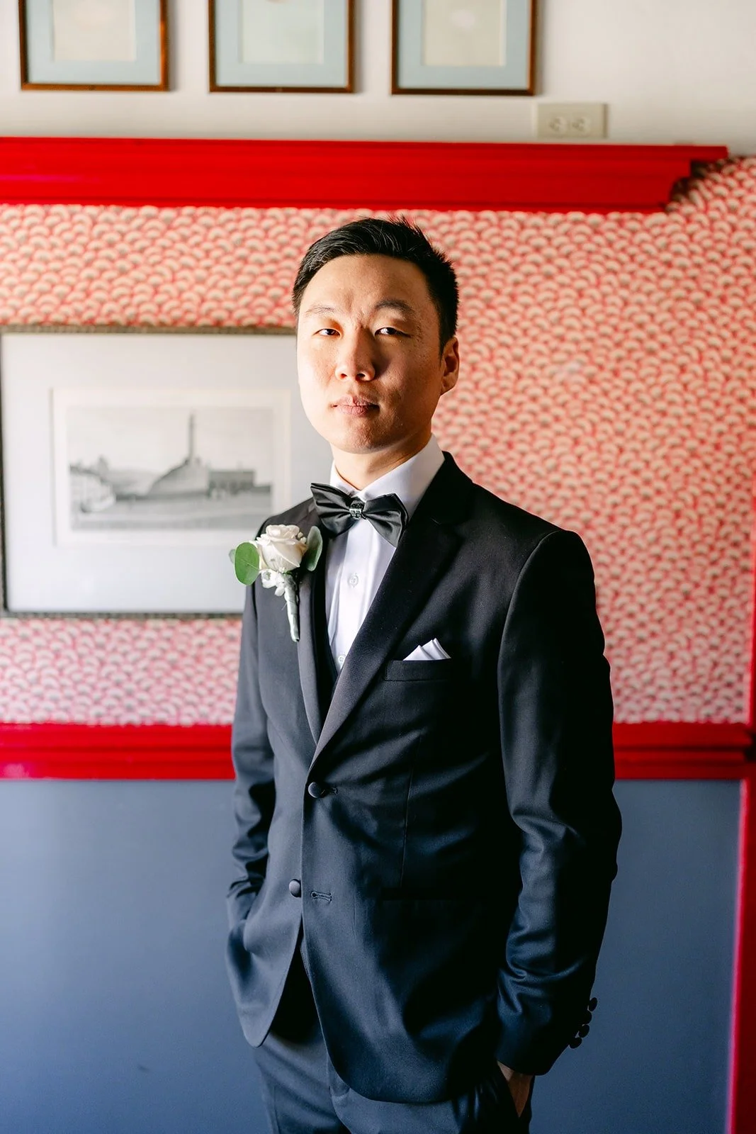 Jason in a black tuxedo and bow tie with a white boutonniere
