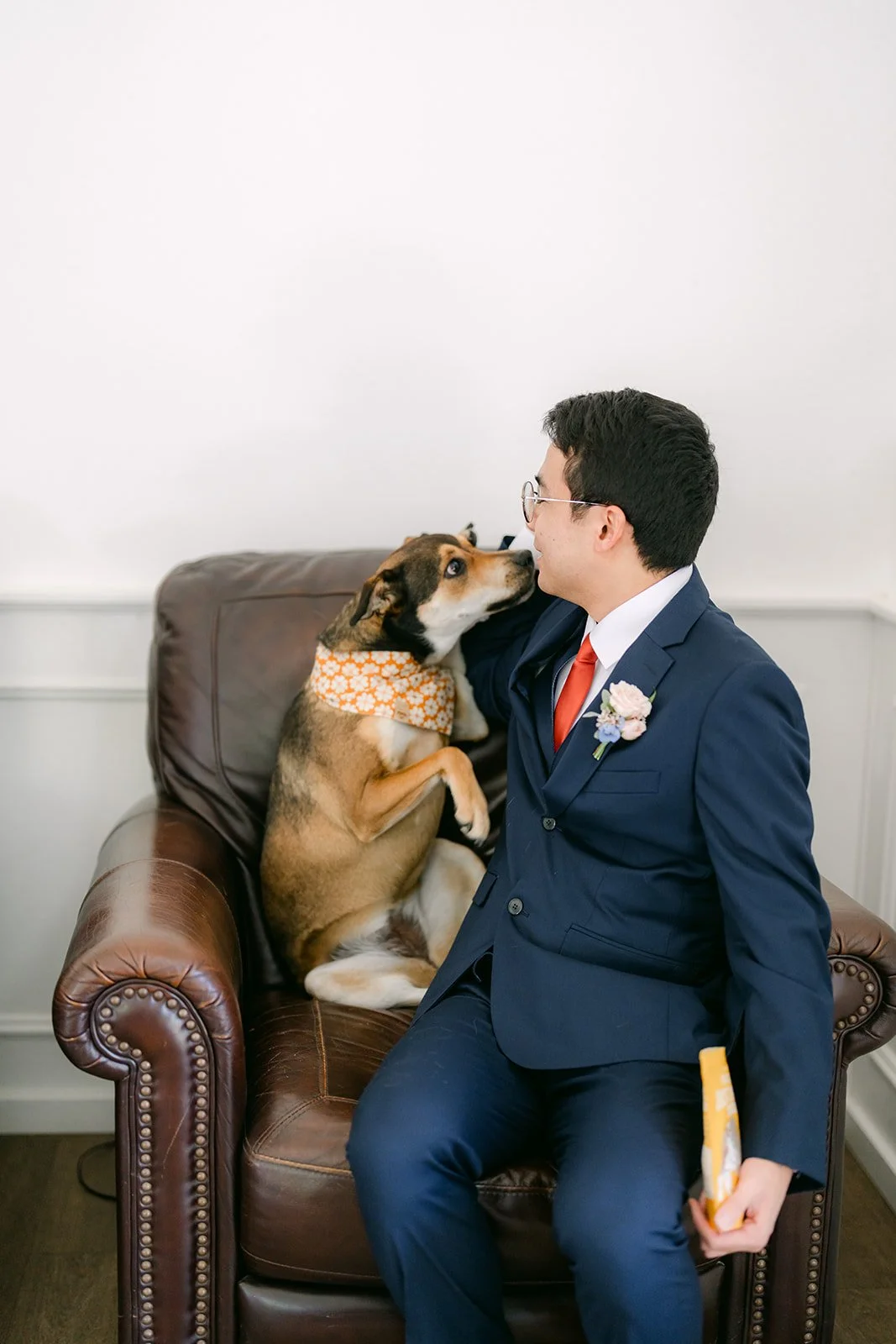 Jonathan sitting in a leather armchair with Bagel on his lap