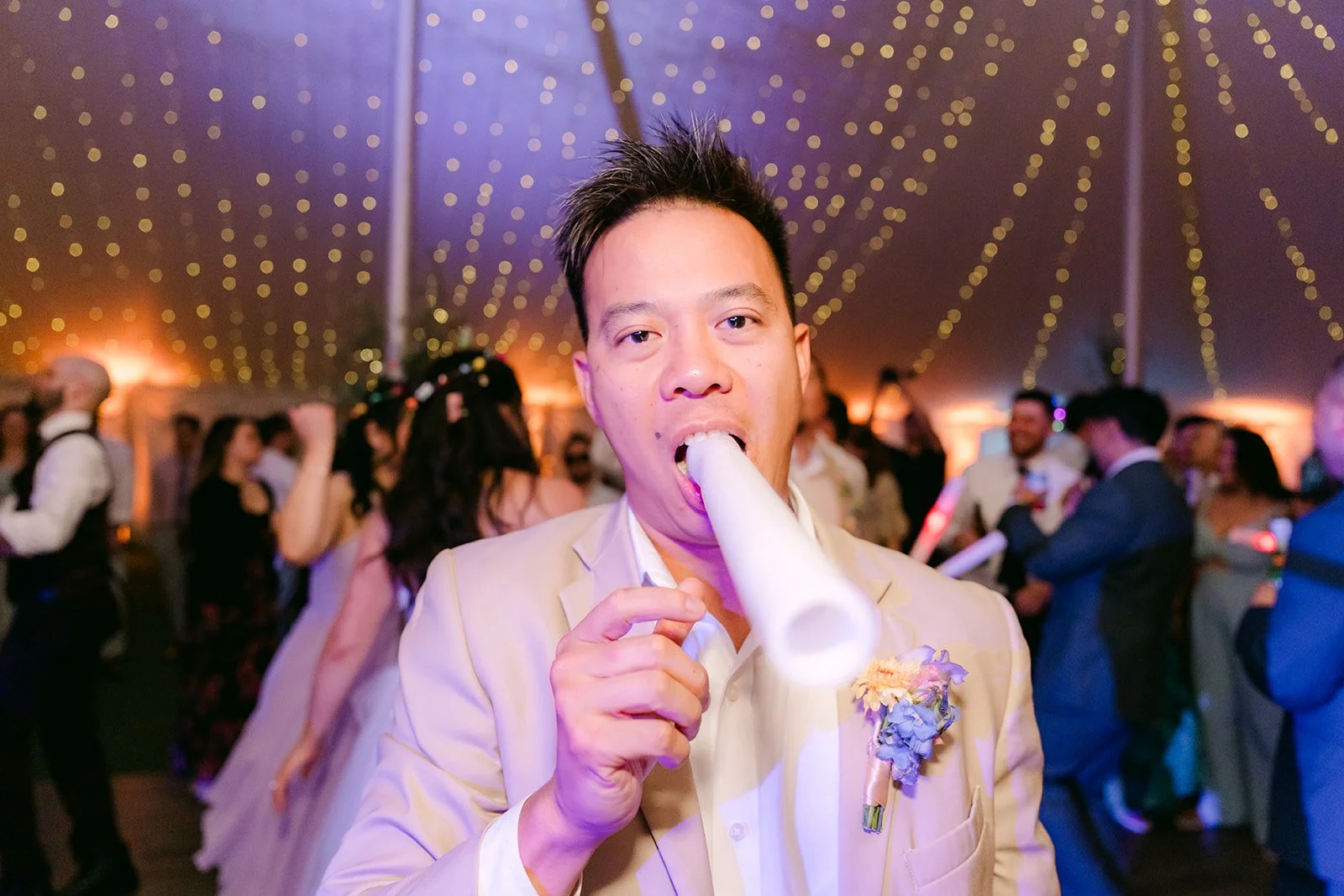 Groomsman singing into a light-up foam stick