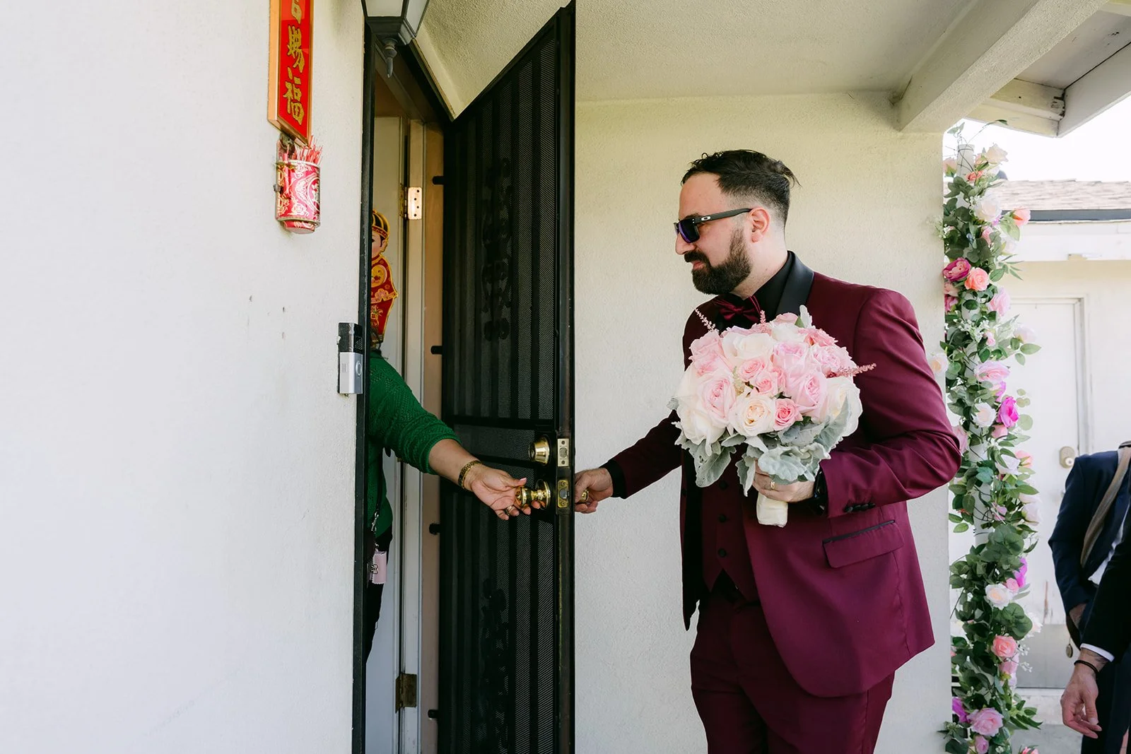 Ryan finally let through the front door with the bouquet.