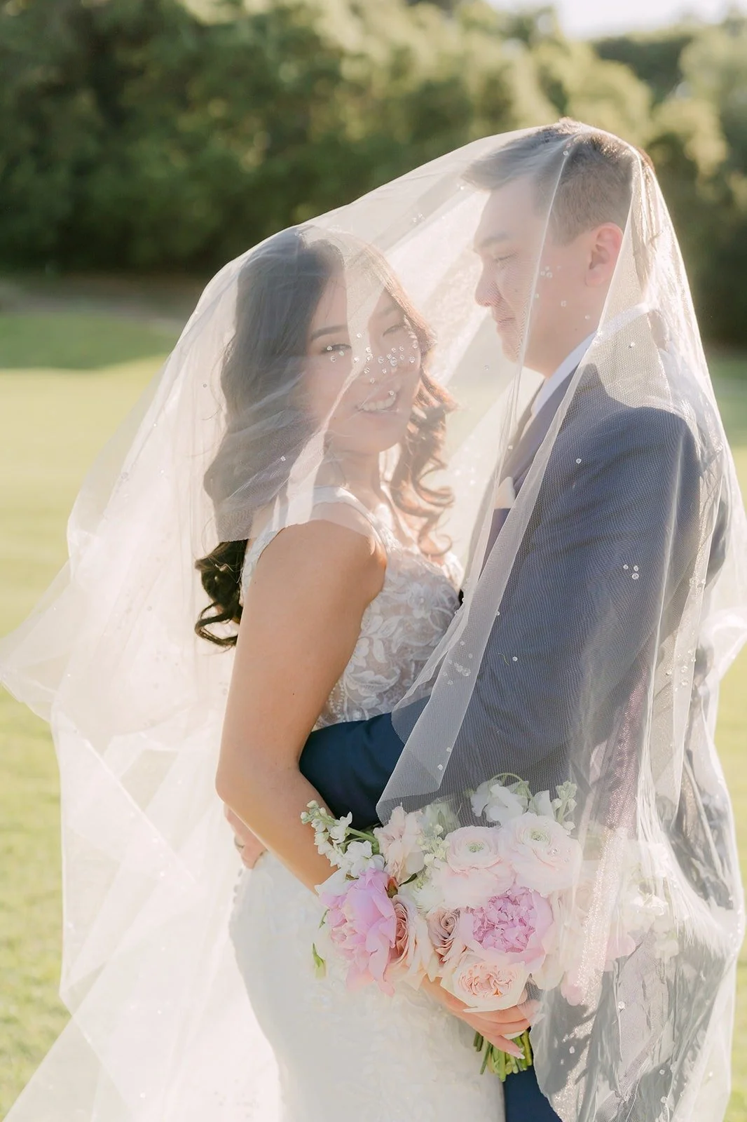 Kelli and Alex nose to nose under her veil in soft afternoon light