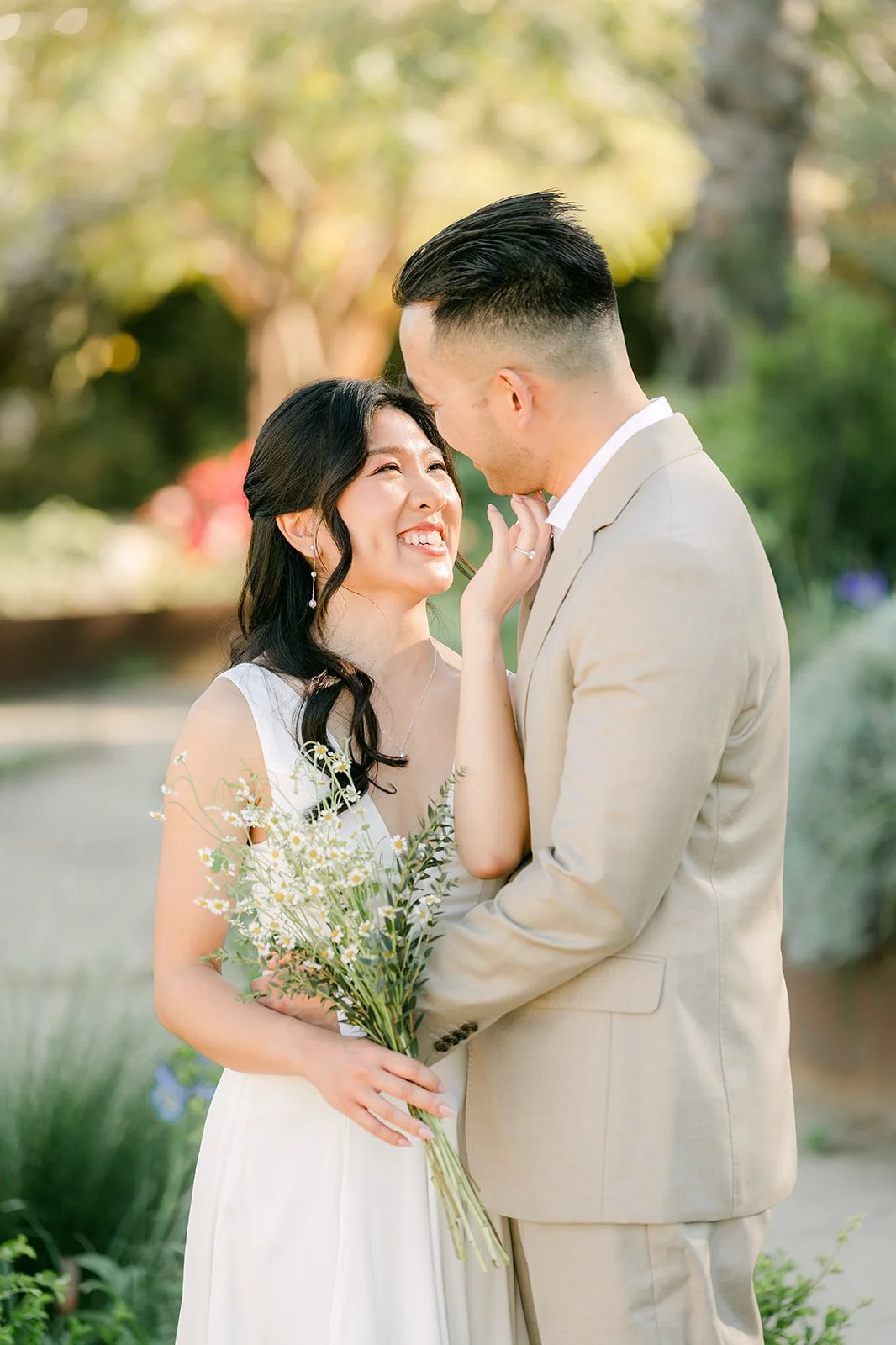 Kim and Vincent in a close embrace on the garden path, photographed by One and Only Production.