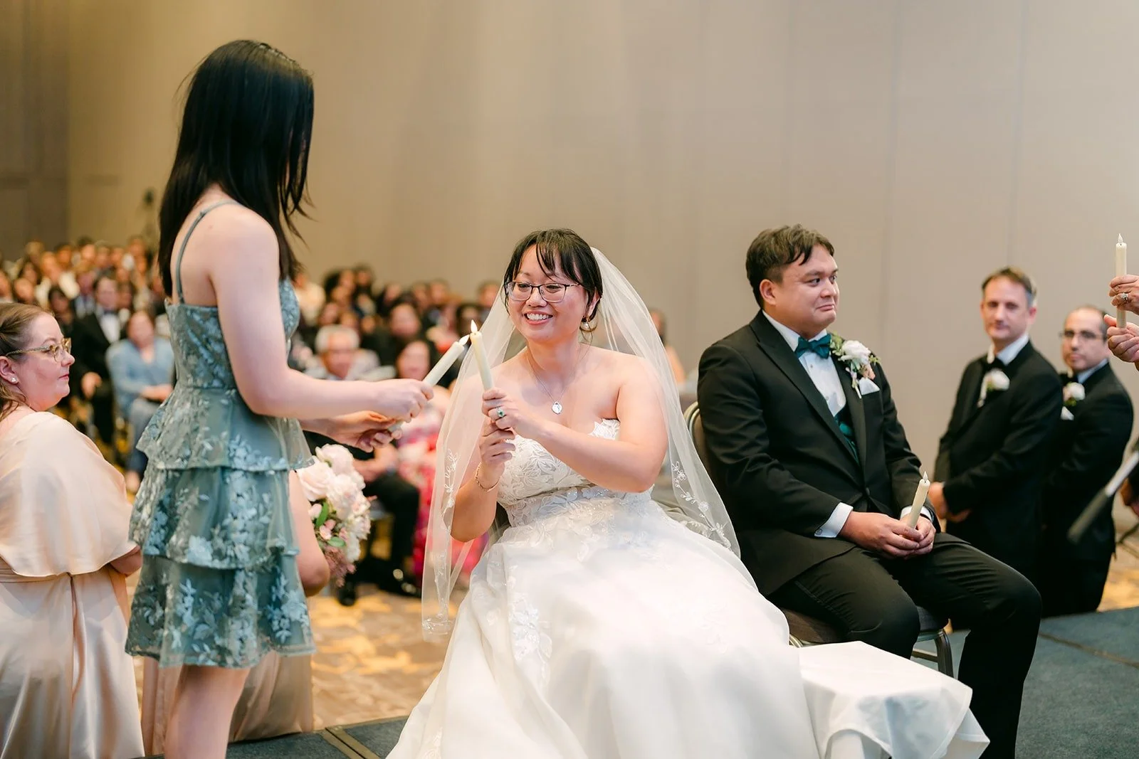 A friend sharing words with Stella and James as they sit side by side during the ceremony