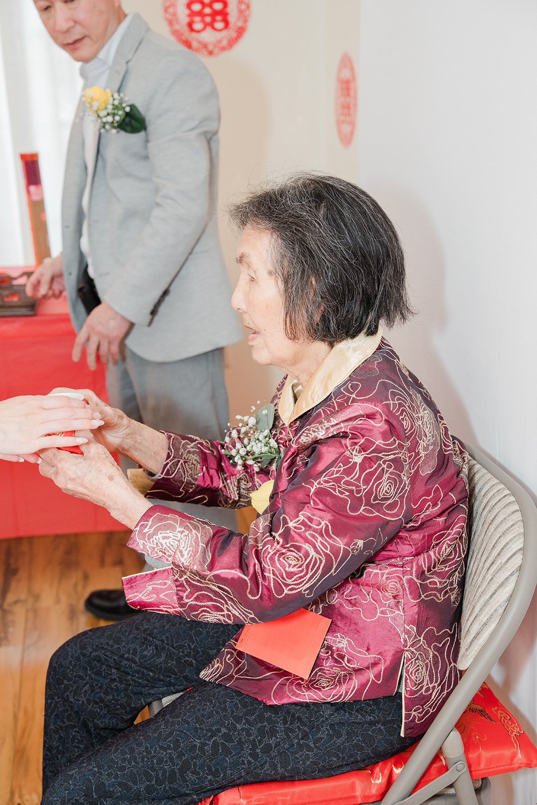 A grandmother seated for the tea ceremony.
