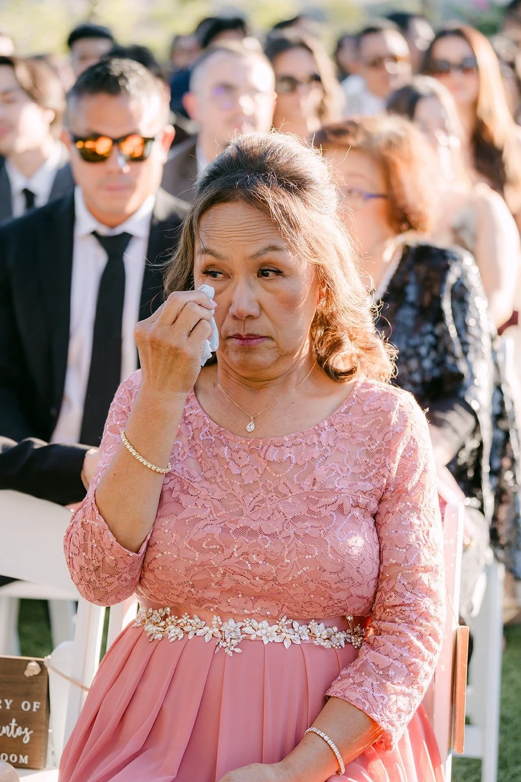 A guest wiping away a tear as the ceremony begins