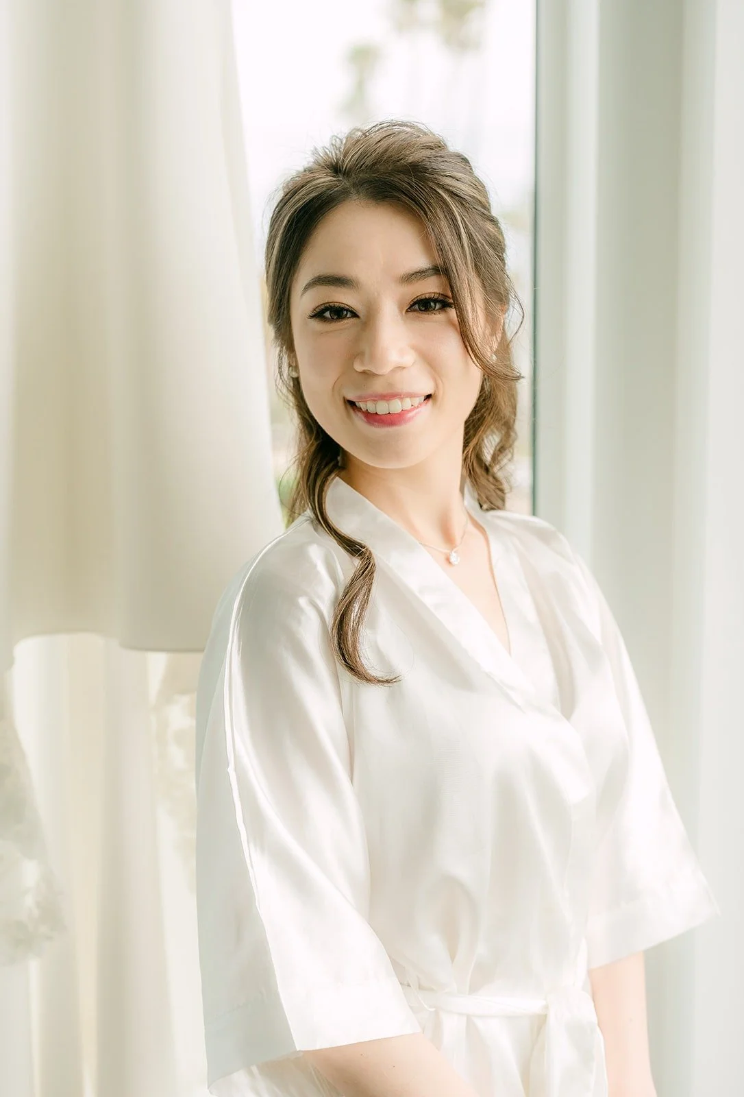 Angela turning toward the window in her white robe