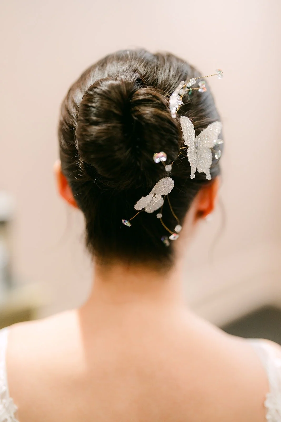 A floral hair piece tucked into Elisa's low bun