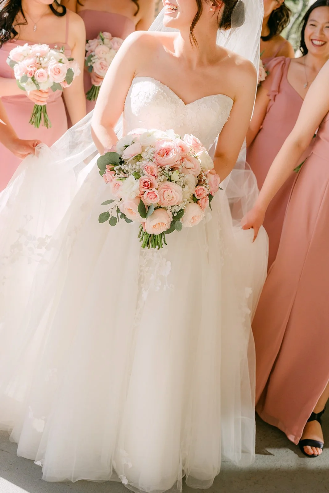 Close-up of the bride's blush and white bouquet with her bridesmaids
