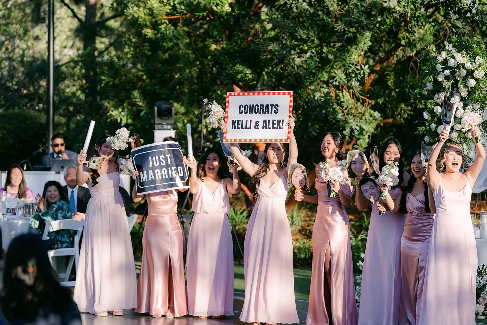 Bridesmaids dancing into the reception holding up signs