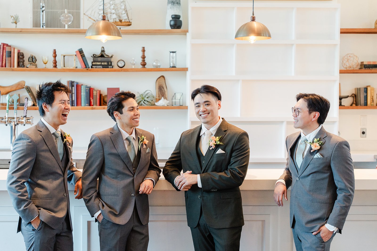 Alex with his groomsmen in grey suits by the bookshelves