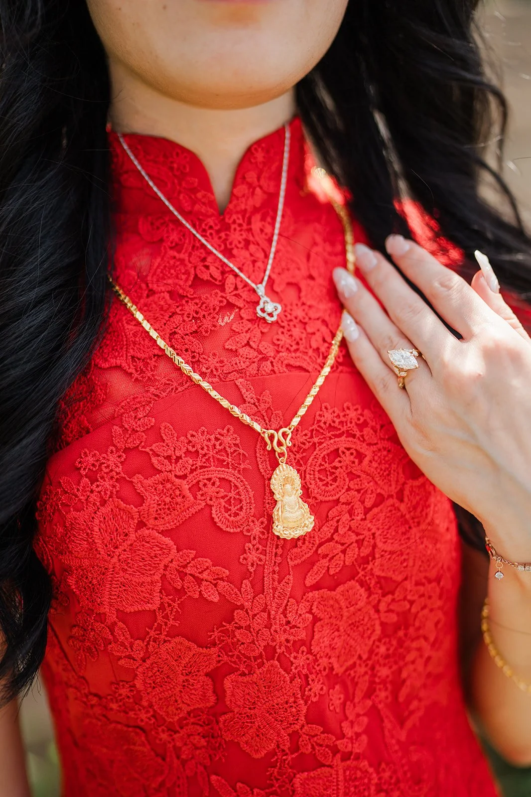 Close up of Valerie's gold necklace and red qipao.