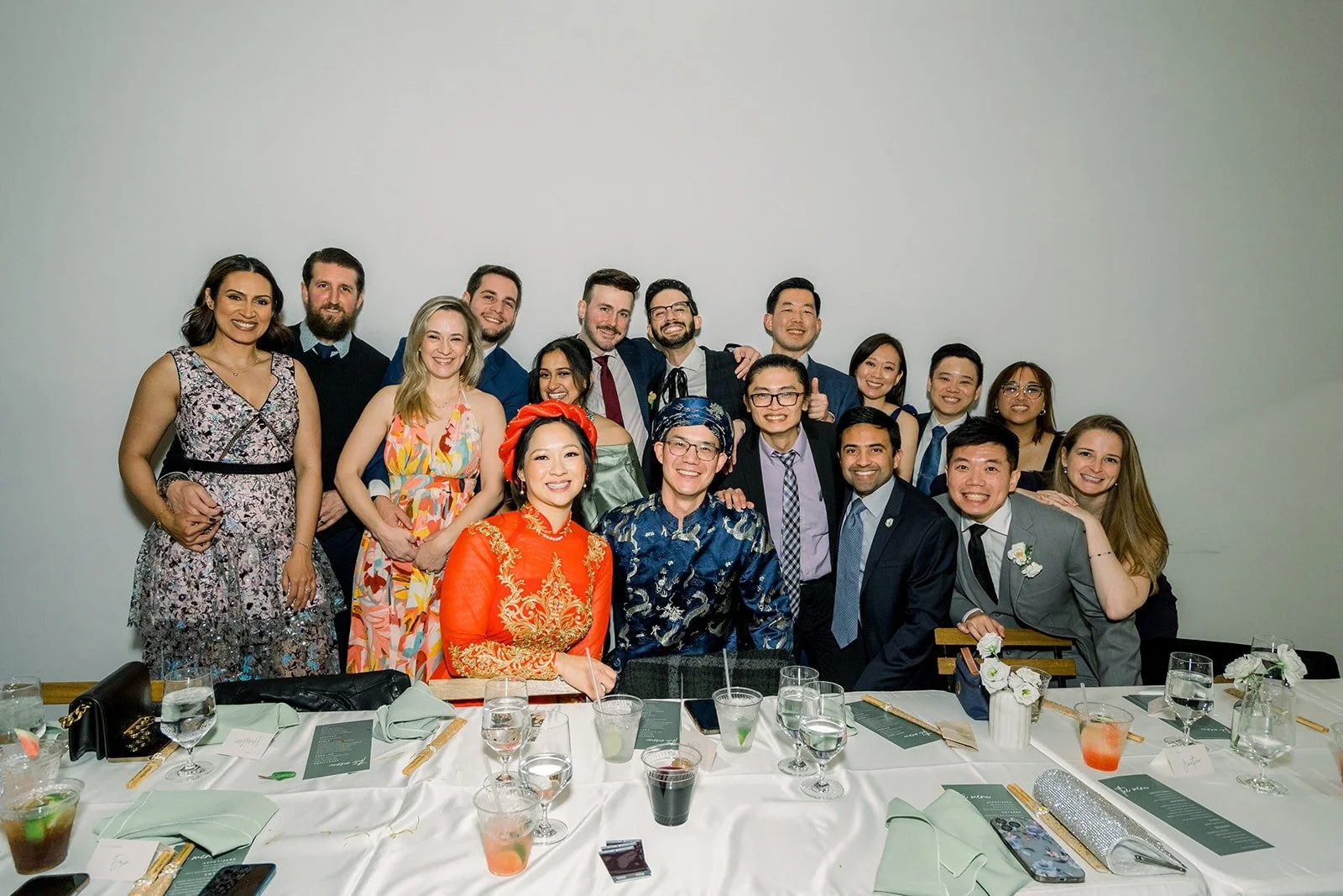A full table of guests gathers behind Cindy and Alex