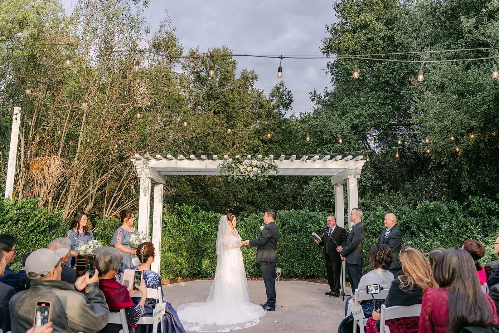A wide view of the ceremony garden at Sierra La Verne with guests seated around the aisle