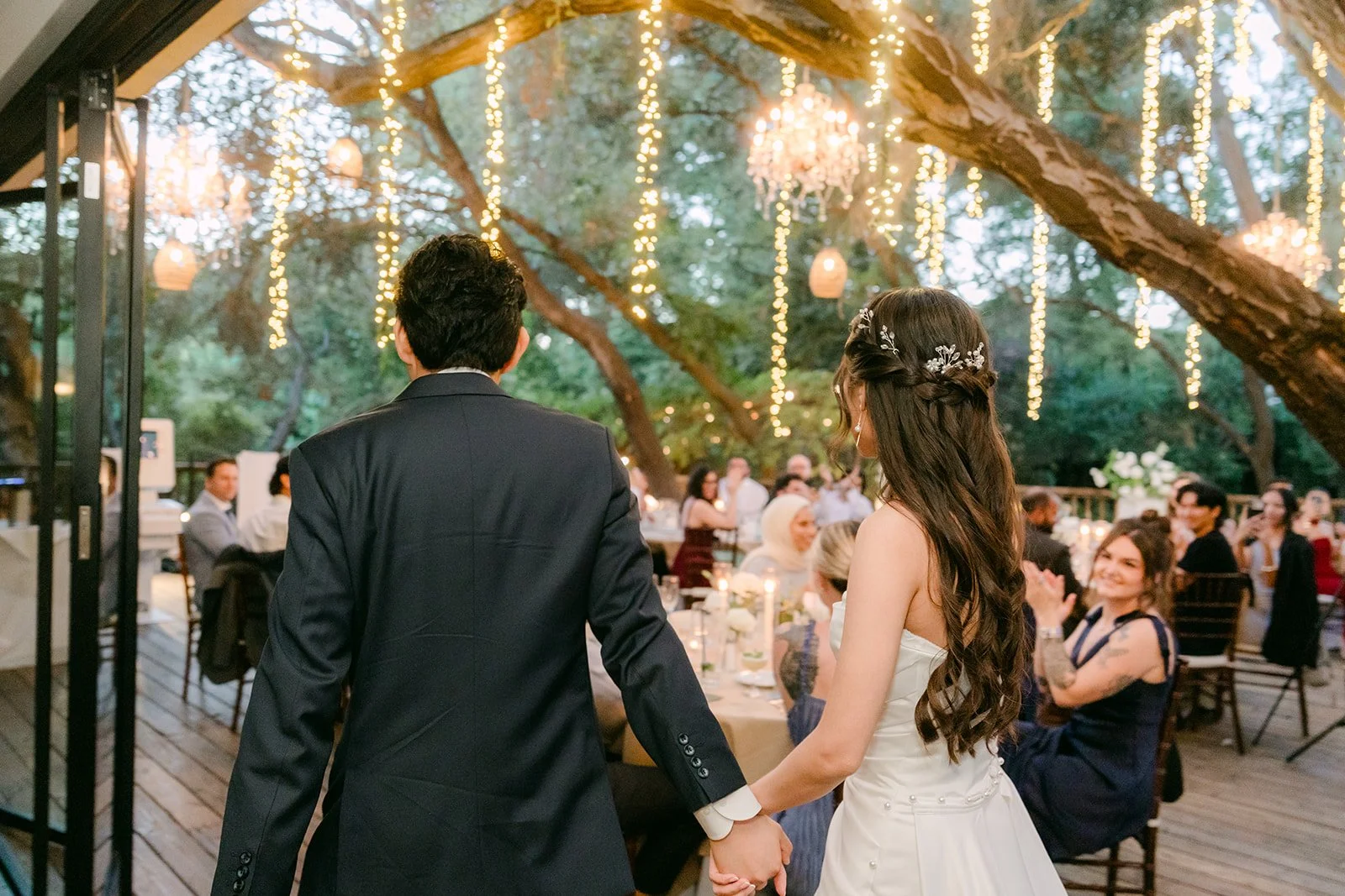 Couple walking into the reception past cheering guests