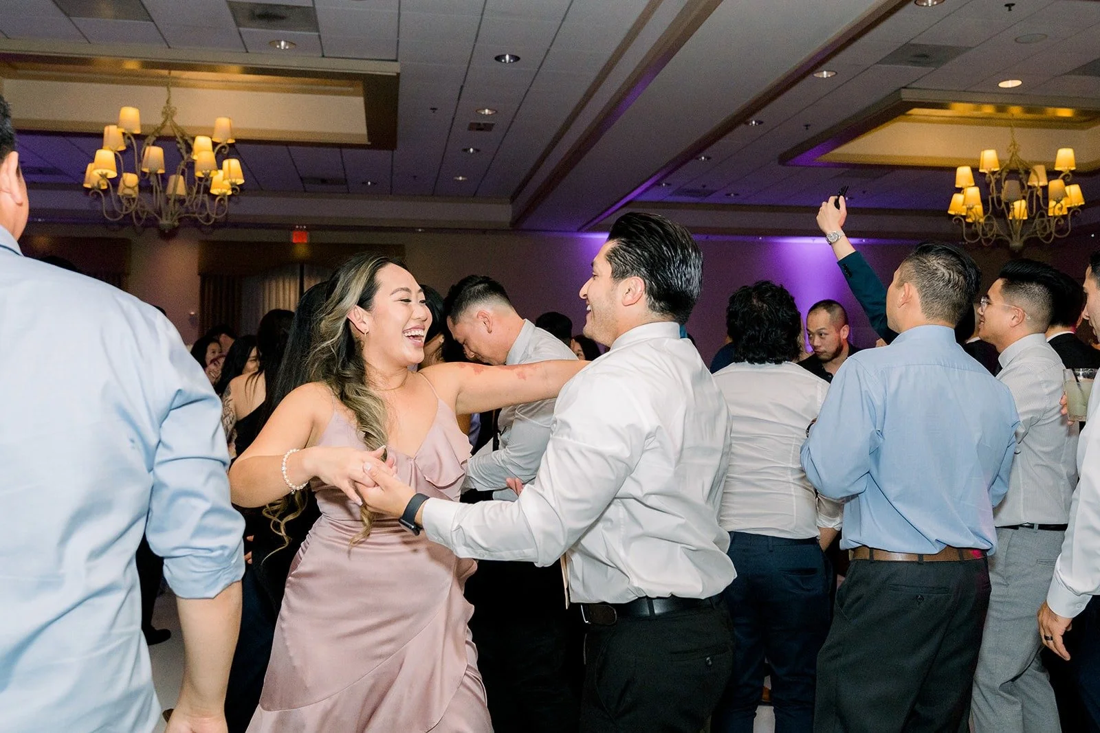 Friends dancing together under the ballroom lights