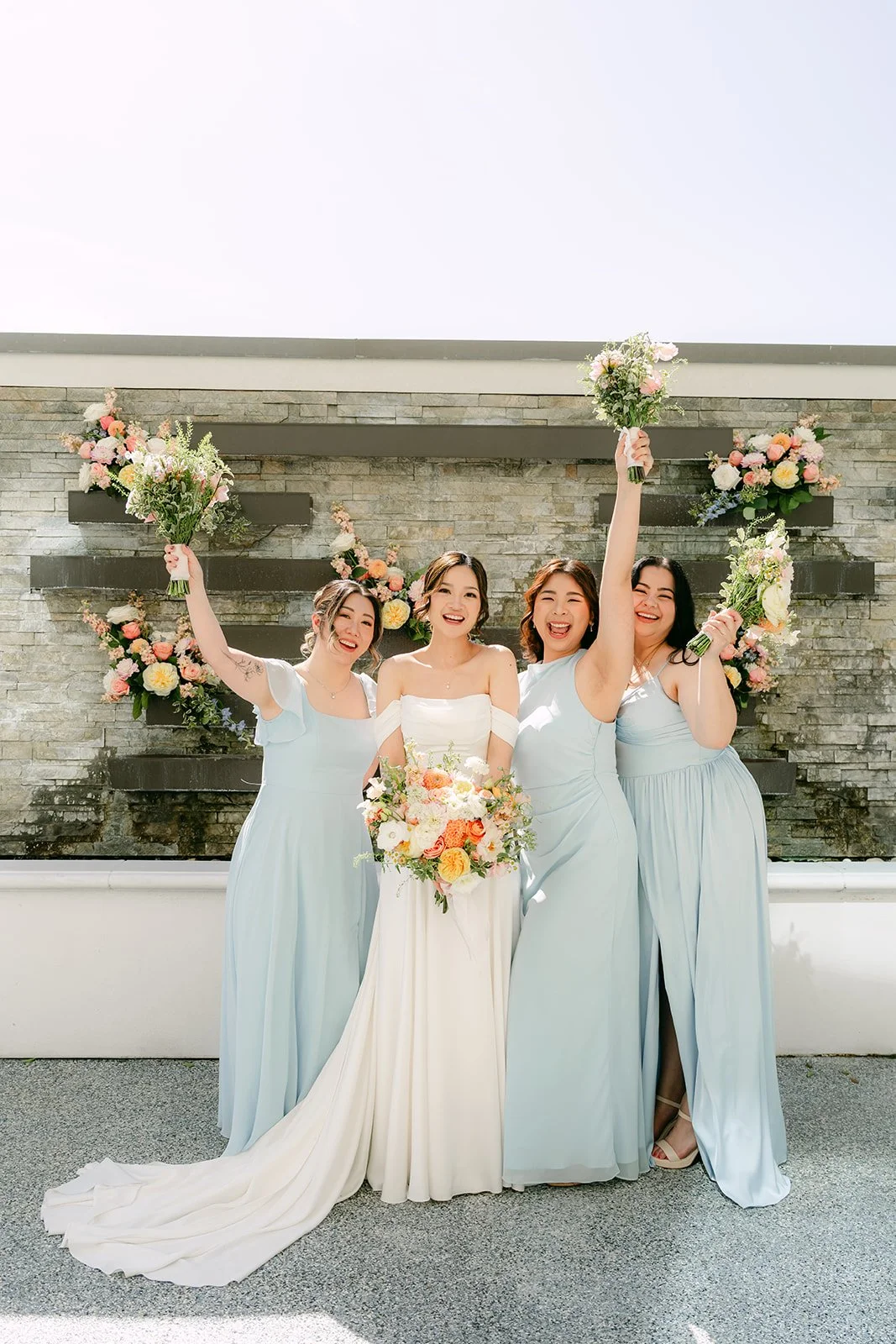 Amanda's bridesmaids cheering with bouquets raised.