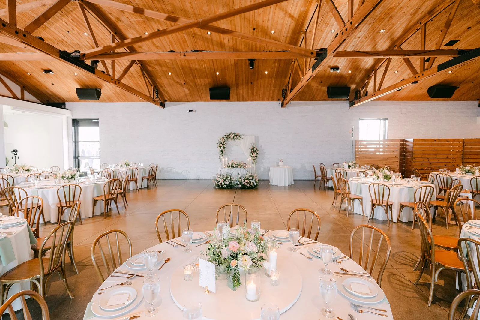Reception tables set under the wood trusses at The Colony House