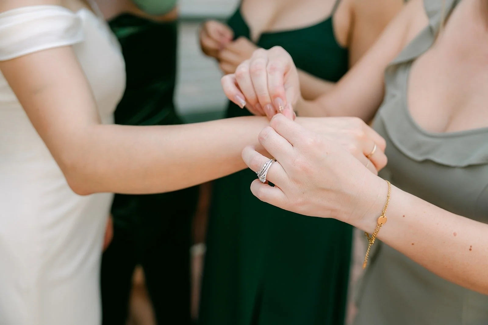 A bridesmaid fastening a bracelet on Mariana's wrist