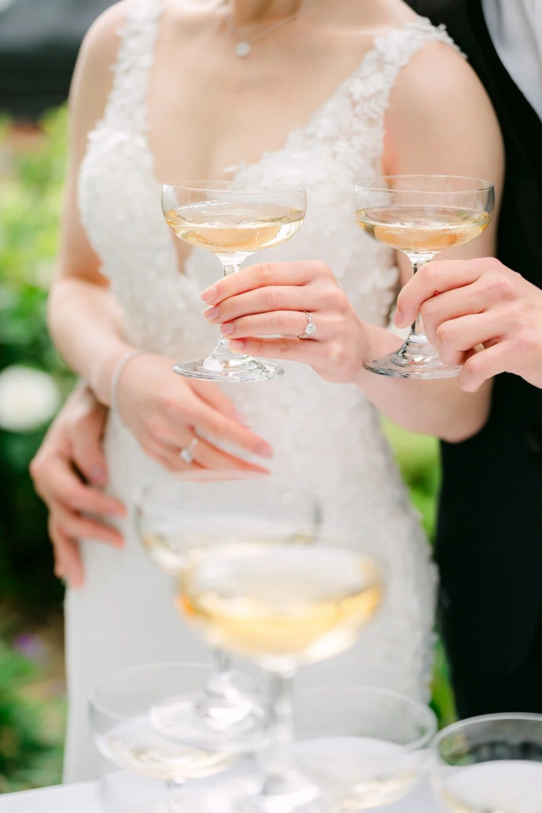 Close up of Angela holding two coupes of champagne